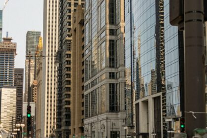 cars on road between high rise buildings during daytime
